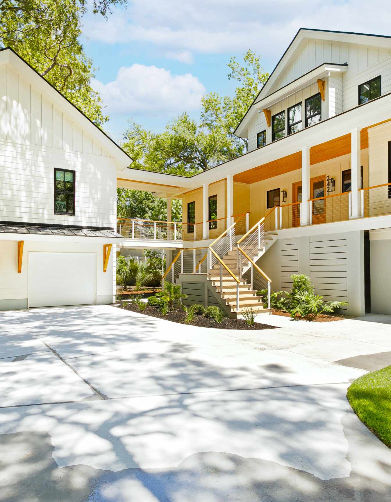 New construction elevated home on Johns Island, SC 29455, featuring a modern exterior and breezeway to a two car garage