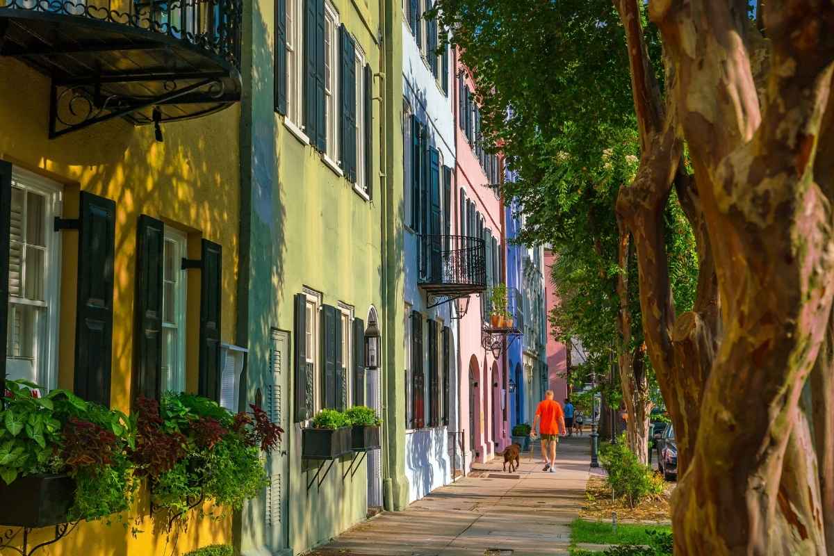 man walking dog on rainbow row in Charleston SC
